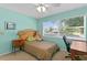 Comfortable bedroom with a bed, desk, and view from the large window at 13548 Lake Magdalene Dr, Tampa, FL 33613