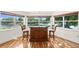 Bonus room with hardwood floors, a bar, and views of the lake through large windows at 13548 Lake Magdalene Dr, Tampa, FL 33613