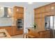 Kitchen with stainless steel appliances, wooden cabinets, tile backsplash, and granite island with seating at 13548 Lake Magdalene Dr, Tampa, FL 33613