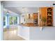 Open kitchen with granite countertops, wooden cabinets, and views of the dining and living areas at 13548 Lake Magdalene Dr, Tampa, FL 33613
