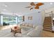 Comfortable living room with lake views featuring a staircase, and sliding glass doors to the backyard at 13548 Lake Magdalene Dr, Tampa, FL 33613