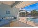 Enjoy this screened patio with cozy blue seating, a lovely pool, and a serene lake view at 13548 Lake Magdalene Dr, Tampa, FL 33613