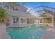 The exterior boasts a screened-in pool, sliding glass doors, and a tranquil view at 13548 Lake Magdalene Dr, Tampa, FL 33613