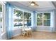 Bright sunroom with pool and lake views framed by sheer blue curtains at 13548 Lake Magdalene Dr, Tampa, FL 33613