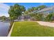 Home's landscaping leads to a screened in back porch, dock, and waterfront access at 13548 Lake Magdalene Dr, Tampa, FL 33613