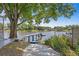 Lakefront access via a dock, a patio, and boat/kayak storage on the side of the home at 13548 Lake Magdalene Dr, Tampa, FL 33613