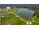 This aerial view shows the community park with the parking lot, walking paths, dog park, and a large pond at 13608 S Village Dr # 6203, Tampa, FL 33618