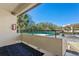 Outdoor balcony with black patterned rug and views of mature trees and a tennis court at 13608 S Village Dr # 6203, Tampa, FL 33618