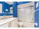 Bathroom features a white vanity, sliding glass door to shower and bright blue wall at 13608 S Village Dr # 6203, Tampa, FL 33618