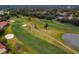 Aerial shot of a golf course with sand traps and a pond, surrounded by residential homes at 13608 S Village Dr # 6203, Tampa, FL 33618