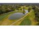 Scenic aerial of golf course with mature trees and a tranquil pond, highlighting the community's outdoor amenities at 13608 S Village Dr # 6203, Tampa, FL 33618