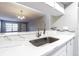 Kitchen sink with stainless steel faucet and quartz countertop, with view to living area at 13608 S Village Dr # 6203, Tampa, FL 33618