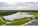 Aerial view of a large lake surrounded by green spaces, walking paths, and community parking areas at 13608 S Village Dr # 6203, Tampa, FL 33618