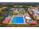Aerial view of a pool, clubhouse, tennis courts, and parking in this vibrant community at 13608 S Village Dr # 6203, Tampa, FL 33618