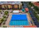 Aerial view of an in-ground pool and area with lounge chairs and palm trees in a colorful community at 13608 S Village Dr # 6203, Tampa, FL 33618