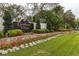 An eye-level view of the decorative community entrance sign, with colorful landscaping and manicured lawn at 13608 S Village Dr # 6203, Tampa, FL 33618