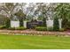An eye-level view of the decorative community entrance sign, with colorful landscaping and manicured lawn at 13608 S Village Dr # 6203, Tampa, FL 33618