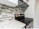 Close up of black stove top with stainless steel trim and stylish backsplash at 13608 S Village Dr # 6203, Tampa, FL 33618