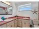 Bright bathroom with double sinks, wood cabinets, and a window for natural light at 13974 75Th Ave, Seminole, FL 33776