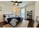 Bright bedroom with dark wood floors, ceiling fan, and decoratively appointed with area rug and shelving at 13974 75Th Ave, Seminole, FL 33776