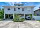 Stilt home with large driveway and parking, complemented by lush landscaping at 13974 75Th Ave, Seminole, FL 33776