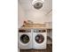 Laundry room with washer, dryer, folding counter, overhead cabinet and modern lighting at 13974 75Th Ave, Seminole, FL 33776