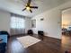Bright living room featuring hardwood floors, large window, ceiling fan, and a glimpse into an adjacent room at 13974 75Th Ave, Seminole, FL 33776
