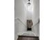 A long, white staircase lit with a modern light fixture and trimmed with wainscotting at 13974 75Th Ave, Seminole, FL 33776