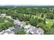 Aerial view of modern townhomes with garages nestled in a lush, green, tree-filled golf course community at 14205 Cypress Ter, Tampa, FL 33618