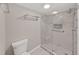 Modern shower with glass doors and grab bar across from toilet and towel rack at 14205 Cypress Ter, Tampa, FL 33618