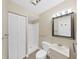 Simple bathroom featuring a toilet, walk-in shower, a sink, and a mirror at 14205 Cypress Ter, Tampa, FL 33618