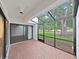 Enclosed patio featuring brick flooring, sliding glass doors, and scenic views of the lush greenery at 14205 Cypress Ter, Tampa, FL 33618