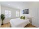 Cozy bedroom with wood floors, white bedding and shuttered windows providing lots of natural light at 1476 Harbour Walk Rd, Tampa, FL 33602