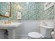 Powder room boasts designer wallpaper, a pedestal sink, and modern fixtures at 1476 Harbour Walk Rd, Tampa, FL 33602