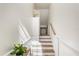 Bright stairway with white risers, wooden treads, and white walls with picture-frame molding at 1476 Harbour Walk Rd, Tampa, FL 33602