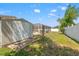 Fenced backyard featuring a storage shed, manicured lawn, and a screened-in pool area at 15428 Atwater Dr, Brooksville, FL 34604