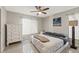 Comfortable bedroom with neutral colors, a ceiling fan, and ample natural light from the window at 15428 Atwater Dr, Brooksville, FL 34604