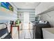 Functional laundry room features washer, dryer, storage cabinets, and beach-themed decor creating an efficient space at 15428 Atwater Dr, Brooksville, FL 34604