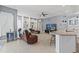 Well-lit living space with a modern TV, kitchen island seating, and sleek granite countertops at 15428 Atwater Dr, Brooksville, FL 34604
