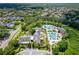 An aerial view displays the community clubhouse and pool amidst green foliage and neighborhood streets at 15635 Starling Water, Lithia, FL 33547
