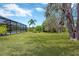Spacious backyard with lush lawn, mature trees, and a screened-in pool area perfect for outdoor enjoyment at 15635 Starling Water, Lithia, FL 33547