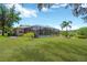 Spacious backyard with a screened-in pool, lush green lawn, and tropical landscaping for outdoor relaxation at 15635 Starling Water, Lithia, FL 33547