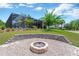 Backyard with a screened-in pool, lush lawn, palm trees, and a stone fire pit for outdoor enjoyment at 15635 Starling Water, Lithia, FL 33547