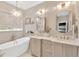 Beautiful bathroom with a standalone tub, dual vanities, stylish mirrors, and modern lighting fixtures at 15635 Starling Water, Lithia, FL 33547