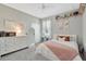 Stylish bedroom with a large bed, dresser, decor, and a well-lit window for natural light at 15635 Starling Water, Lithia, FL 33547