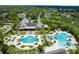 Overhead view of a community clubhouse and pools surrounded by lush greenery and meticulously maintained grounds at 15635 Starling Water, Lithia, FL 33547