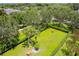 A beautifully landscaped common area with benches, palm trees, and manicured hedges provides a serene outdoor setting at 15635 Starling Water, Lithia, FL 33547