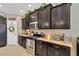 Modern kitchen featuring dark wood cabinets and stainless steel appliances at 15635 Starling Water, Lithia, FL 33547