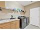 Laundry room features cabinets, counter space, wire shelving, a sink, and modern, front-loading washer and dryer at 15635 Starling Water, Lithia, FL 33547