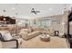 Bright living room with a plush sofa, accent chair, and seamless transition to an outdoor patio at 15635 Starling Water, Lithia, FL 33547